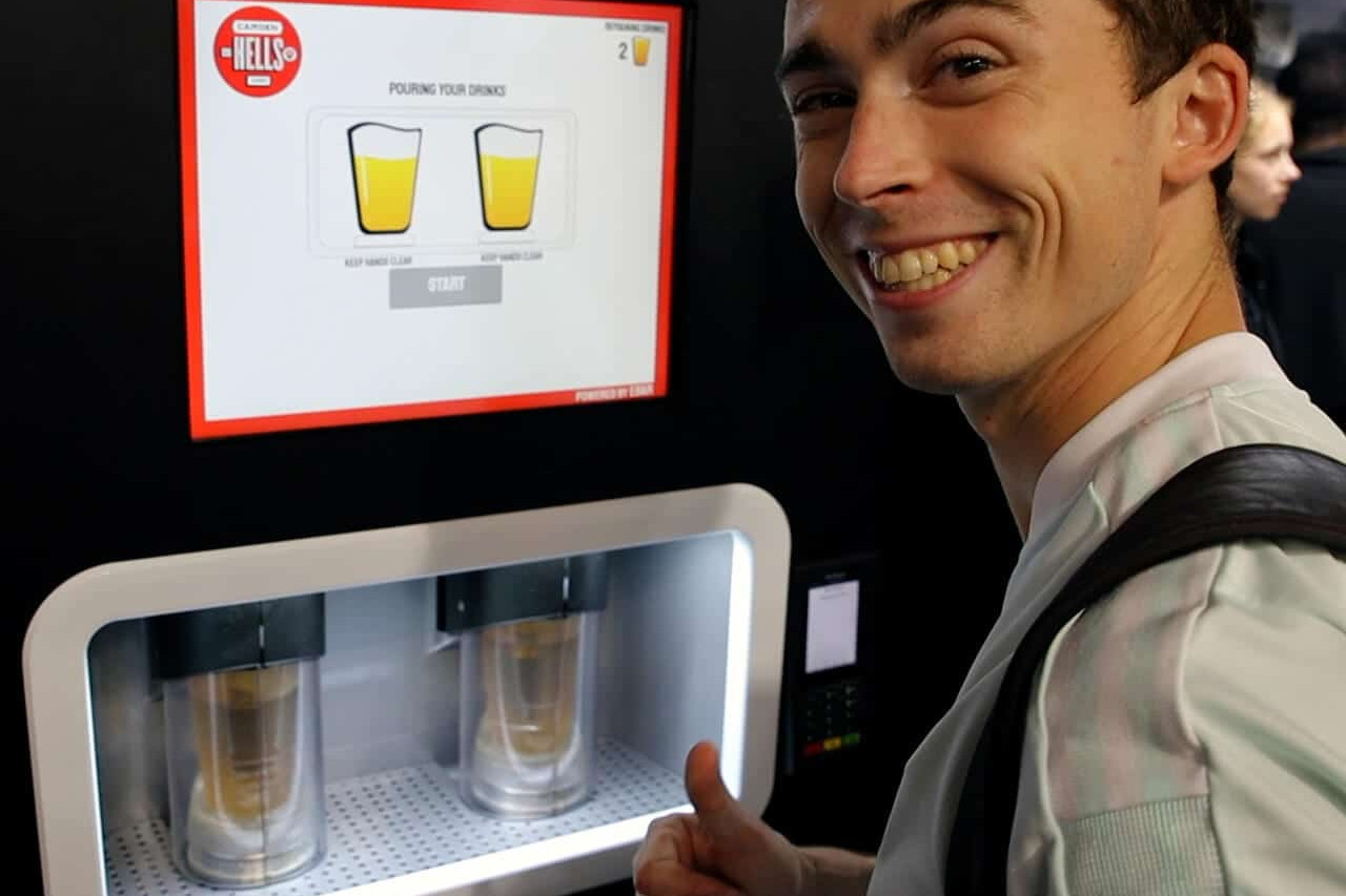 A happy man smiles and raises his thumb as his two pints of lager pour in the EBar unit in front of him