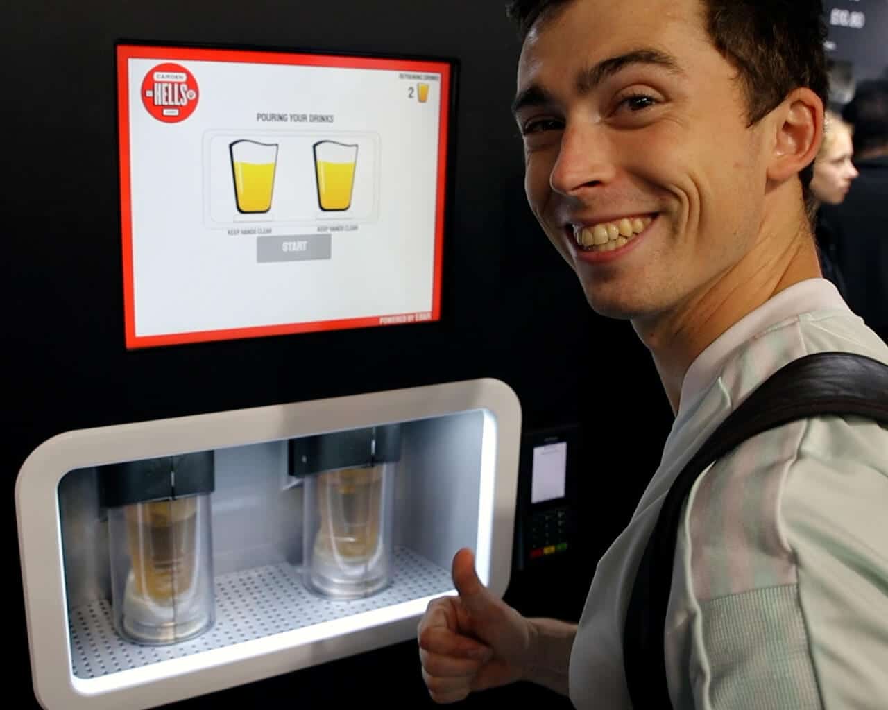 A happy man smiles and raises his thumb as his two pints of lager pour in the EBar unit in front of him