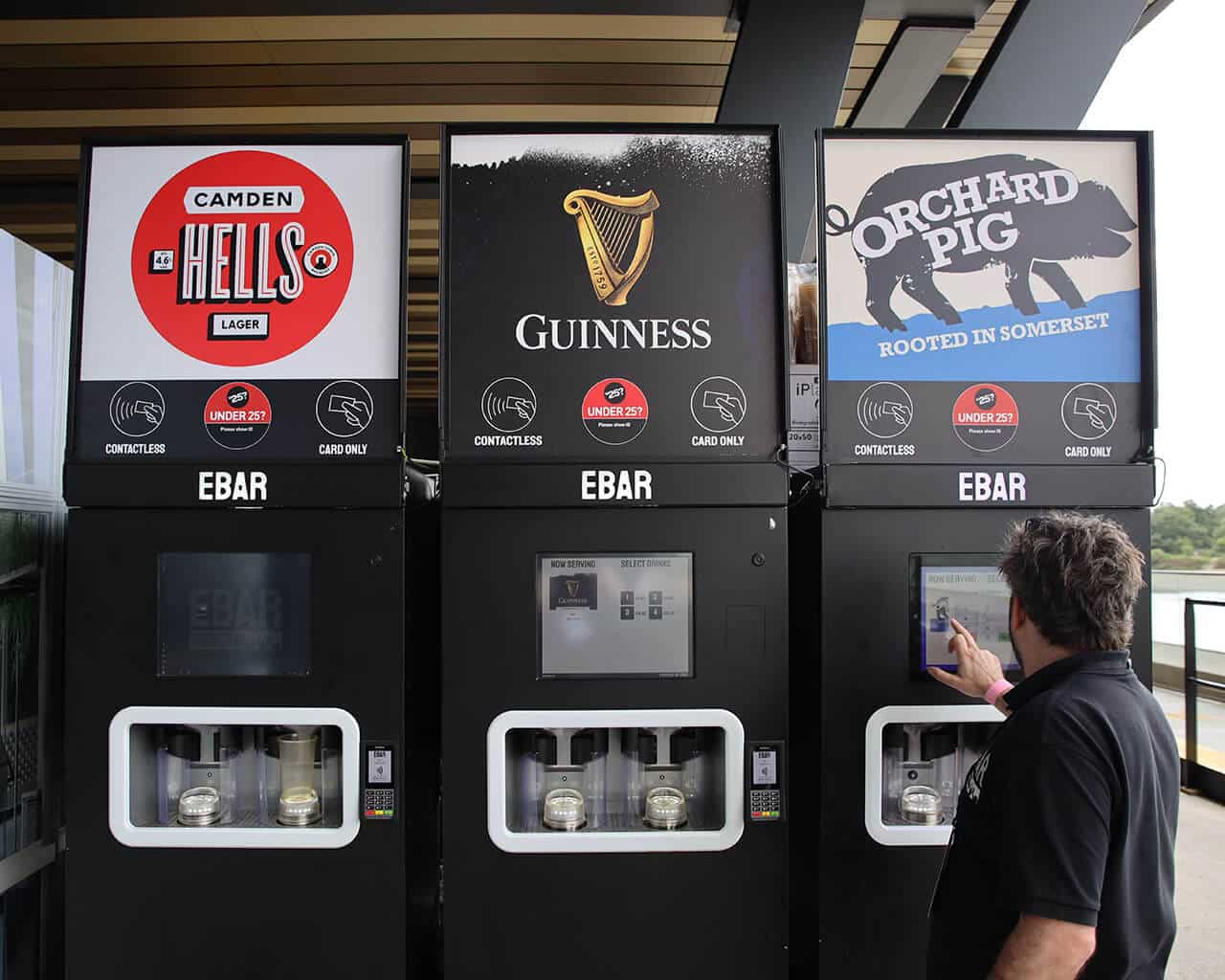 An EBar technician uses a touchscreen to test one of the three mobile EBar units he has just set up